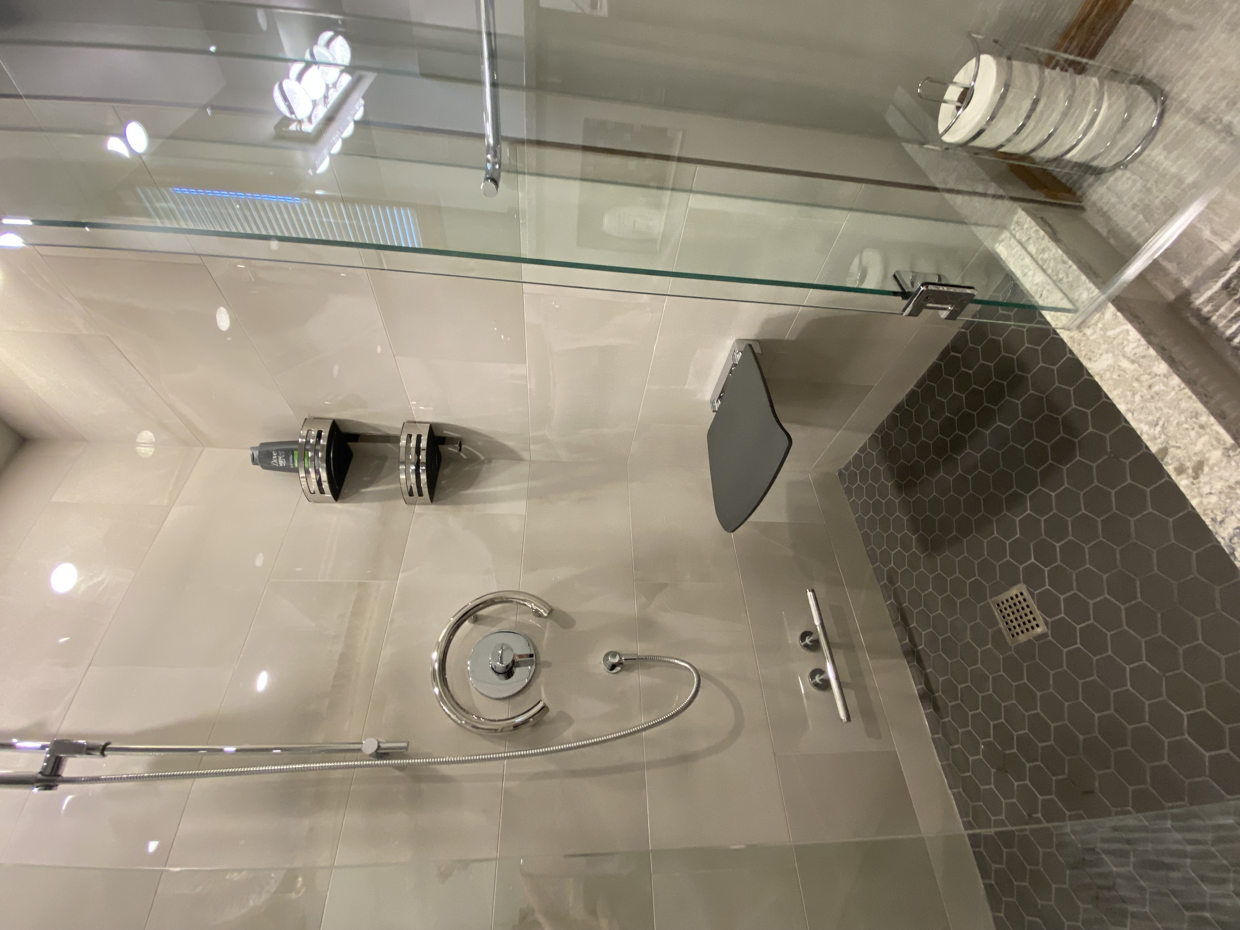 a shower with a seat, grab bars, and a shower head